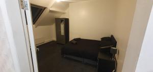 a bedroom with a black bed and a hallway at Hustlers inn apartment in Newcastle upon Tyne