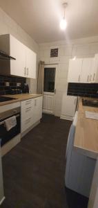 eine Küche mit weißen Schränken und einer Arbeitsplatte in der Unterkunft Hustlers inn apartment in Newcastle upon Tyne