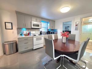 a kitchen with a wooden table and chairs in it at Park view South of Boston - Quincy in Quincy