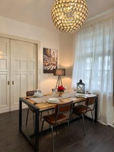 einen Esstisch mit Stühlen und einem Kronleuchter in der Unterkunft bee Design Apartment + Zentral + Küche + Parken in Wetzlar