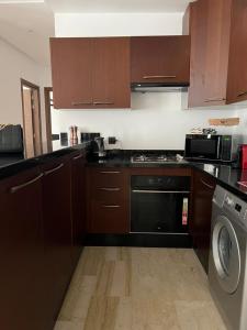 a kitchen with brown cabinets and a dishwasher at Luxury spacious 3 Bed apt with pool in Agadir