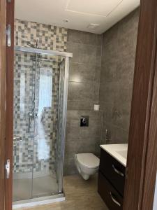 a bathroom with a shower and a toilet and a sink at Luxury spacious 3 Bed apt with pool in Agadir