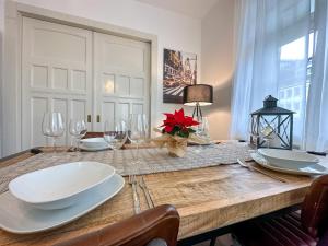 einen Esstisch mit weißen Tellern und Weingläsern in der Unterkunft bee Design Apartment + Zentral + Küche + Parken in Wetzlar