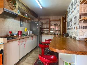 una cocina con encimera y taburetes rojos. en Céntrico Depto 2 habitaciones en Pto Montt con estacionamiento, en Puerto Montt