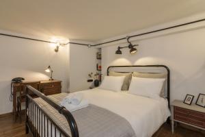 1 dormitorio con 1 cama blanca grande y suelo de madera en Stoa Kairi Loft B, en Atenas
