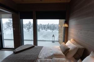a bedroom with a large bed and a large window at Villa Primus in Ruka