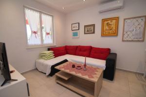 sala de estar con sofá rojo y mesa en Amelia, en Mali Lošinj