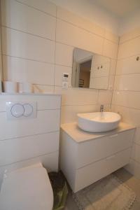 een witte badkamer met een wastafel en een toilet bij Amelia in Mali Lošinj