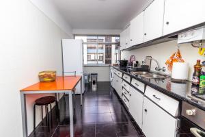 uma cozinha com armários brancos e um balcão laranja em AL Cacém em Paiõis