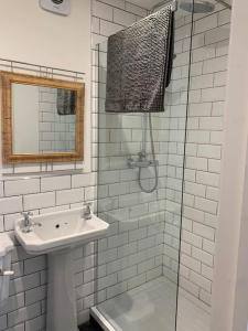 a white bathroom with a sink and a shower at Walkers Rest! in Alfriston