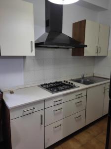 a kitchen with white cabinets and a stove top oven at La Casa dei Nonni in Castagneto Carducci