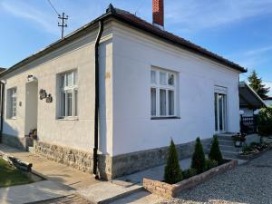 a white house with a chimney on a street at Bela Vila in Negotin