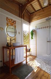 a bathroom with a table and a mirror on a wall at Country Lodge La Pléiade in Sainte-Anne
