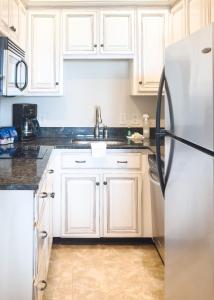 a kitchen with white cabinets and a refrigerator at Sea Gate Inn in Saint Simons Island