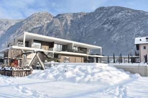 a building in the snow with mountains in the background at Feldhof Vilpian- Urlaub auf dem Bauernhof in Vilpiano