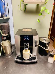 une cafetière assise sur un comptoir avec une tasse dans l'établissement Doppelzimmer 1 I geteiltes Bad & Küche I mit dem Zug nur 4 min bis zum Hauptbahnhof, à Fribourg-en-Brisgau