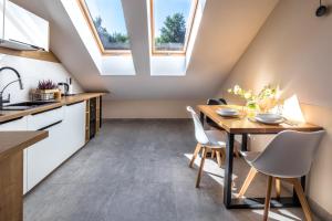 a kitchen with skylights and a wooden table and chairs at Big Marc in Krynica Zdrój