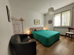 a bedroom with a green bed and a couch at Casa Mina Mountain Lake Iseo Hospitality in Bossico