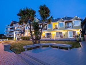 een bankje voor een huis met palmbomen bij Inn of the Four Winds Seaside Oceanfront in Seaside