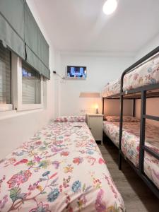 a bedroom with two bunk beds and a tv at Nuestro Rinconcito del Soho in Málaga