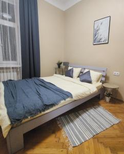 een slaapkamer met een bed met een blauwe deken erop bij В центрі м.Чернівці 2 кімнатна затишна квартира. in Tsjernivsi