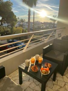 un tavolo con vassoio di cibo e bevande su un balcone di Seafront - beautiful flat with aircon and comfortable loggia a Vallauris
