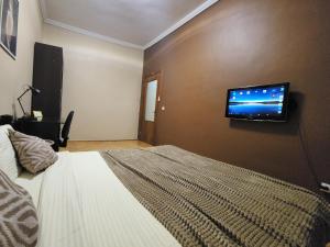 een slaapkamer met een bed en een flatscreen-tv aan de muur bij В центрі м.Чернівці 2 кімнатна затишна квартира. in Tsjernivsi