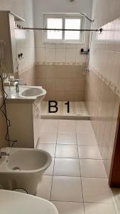 baño con lavabo y aseo y ventana en Dritëza, en Korçë