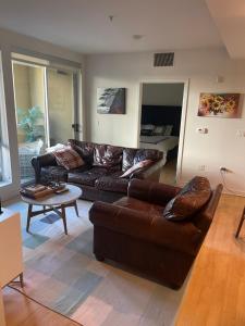 a living room with a leather couch and a table at Super-Cute 2/2 apartment in Santa Monica with free parking in Los Angeles