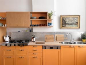a kitchen with orange cabinets and a sink at Appartement spacieux & calme avec vue sur l'Escaut in Tournai