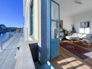 a living room with a large door and a couch at Appartement spacieux & calme avec vue sur l'Escaut in Tournai