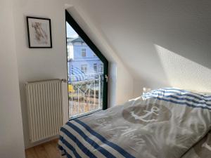 a bedroom with a bed and a large window at Villa Seewind "Pier 15" in Dahme