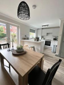 a dining room and kitchen with a wooden table and chairs at The Cottage, a perfect getaway! in Southport