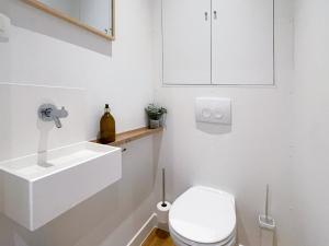 a white bathroom with a toilet and a sink at Appartement spacieux & calme avec vue sur l'Escaut in Tournai
