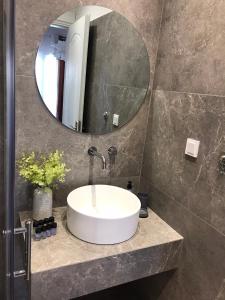 a bathroom with a white sink and a mirror at Artemis Apartments in Diakopto