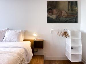 1 dormitorio con 1 cama y una pintura en la pared en Appartement spacieux & calme avec vue sur l'Escaut, en Tournai