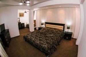 a bedroom with a large bed and two night stands at HOTEL CORA Bistrita in Bistriţa