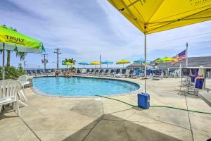 a swimming pool with chairs and umbrellas at North Wildwood Condo - Beach Across Street! in North Wildwood