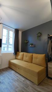 a couch in a living room with a window at Studio confortable au cœur de Rouen in Rouen