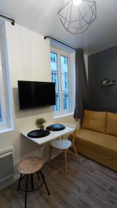 een woonkamer met een bureau en een bank bij Studio confortable au cœur de Rouen in Rouen