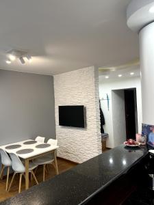 Una sala de estar con una mesa y sillas y un televisor. en Apartament Tuwima 6, en Ełk 25 fotos más