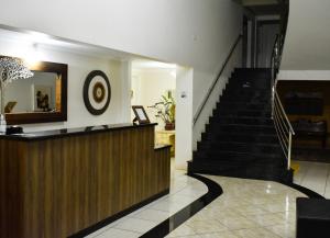 a lobby with a staircase and a mirror at Hotel Monet in Erechim
