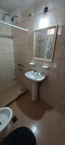 y baño con lavabo y espejo. en Alojamientos Litoral - Casa del Sol en Gualeguaychú