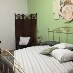 a bedroom with a bed with a green wall at B&B Ciritorno in Vittoria