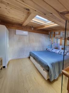sypialnia z łóżkiem z niebieską pościelą i drewnianymi sufitami w obiekcie Apartamento Santa Agueda w mieście Burgos