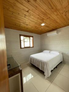 1 dormitorio con cama y techo de madera en Casa Em Ponta Das Canas, en Florianópolis