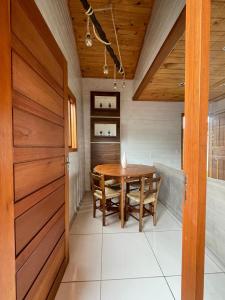 comedor con mesa de madera y sillas en Casa Em Ponta Das Canas, en Florianópolis