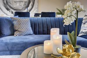 a blue couch with candles on a glass table at The Penthouse - Allocated Parking with City Views in Ripon
