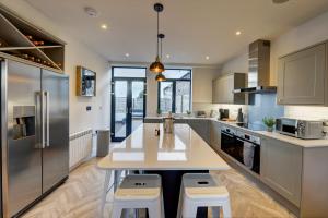 a kitchen with a table and two stools at The Penthouse - Allocated Parking with City Views in Ripon