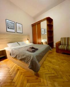 una camera con un grande letto e una sedia di ROMANTIC Apartments - city center 5 15 a Lviv